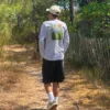 Mélésime2 Promeneur en T-shirt manches longues « Millésime » Estey sur un chemin de sable entre les pins, en Gironde